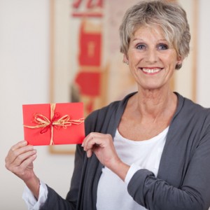 Smiling elderly woman showing a decorated envelope